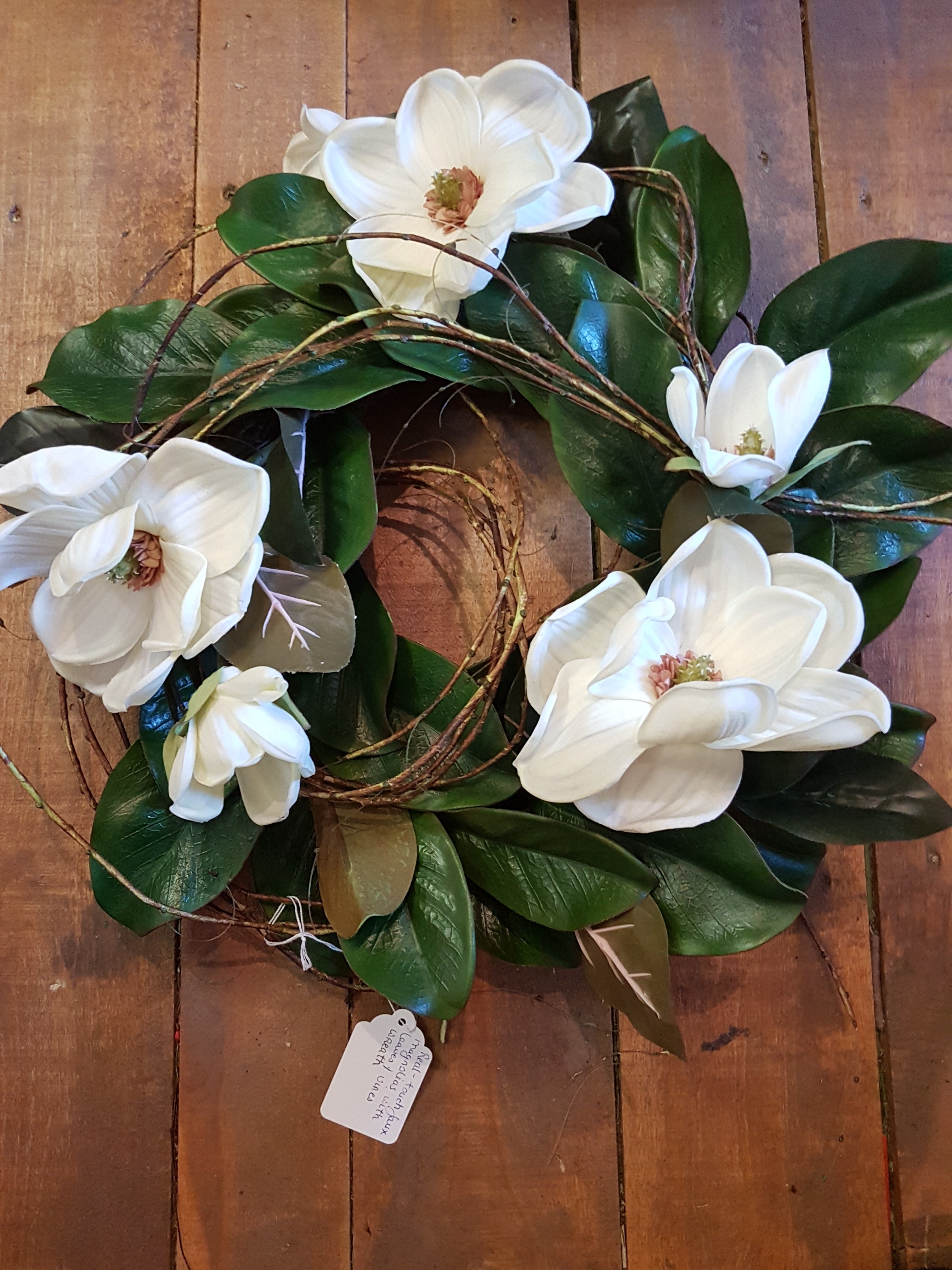 Magnolia wreath with faux flowers.