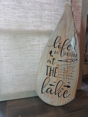 wooden paddle with stencilled saying